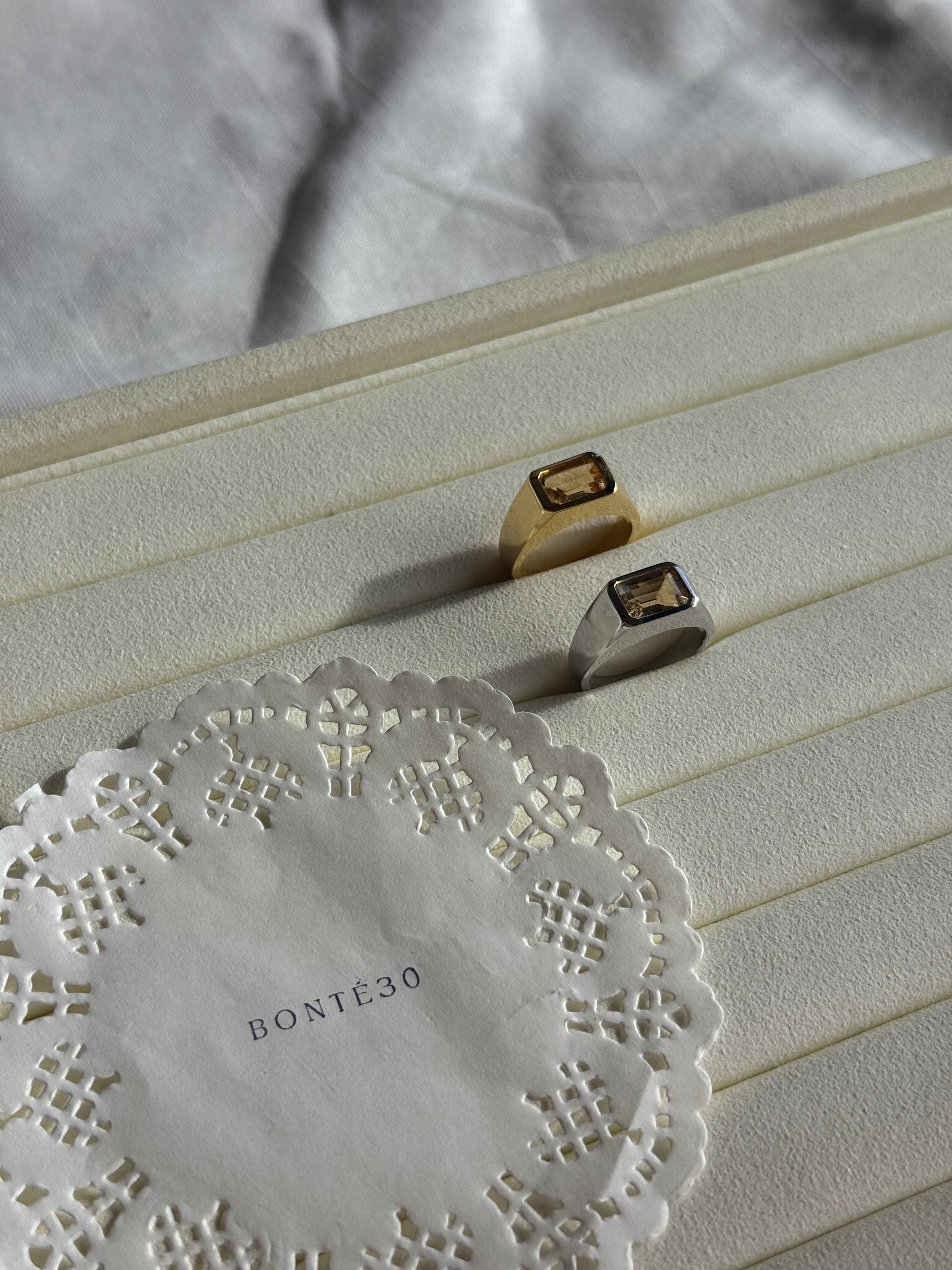 Bonté30 Asher ring in gold vermeil with a rectangular citrine gemstone. A second ring in silver tone is also visible.